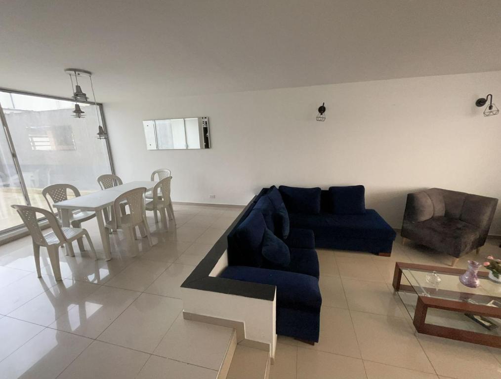 波哥大Casa Chimenea a 5 minutos del Aeropuerto的客厅配有蓝色的沙发和桌子