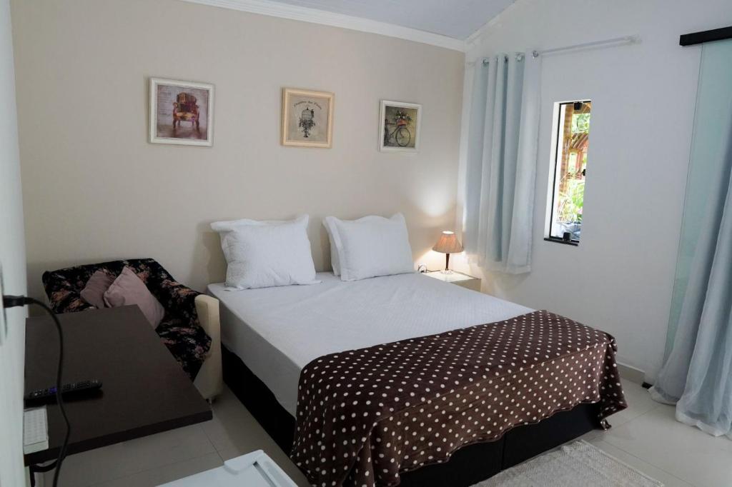 卢米亚Refúgio da Montanha - Cascata - Lumiar的一间卧室配有一张床和一把椅子