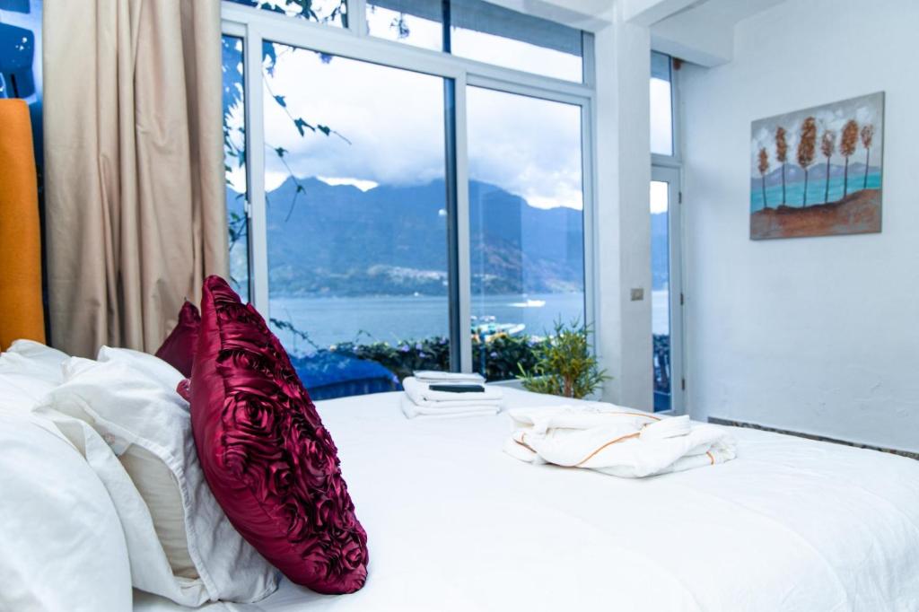 圣佩德罗拉拉古纳TIBERIAS by luxury Atitlan的一间卧室配有一张带红色枕头的床和一扇窗户