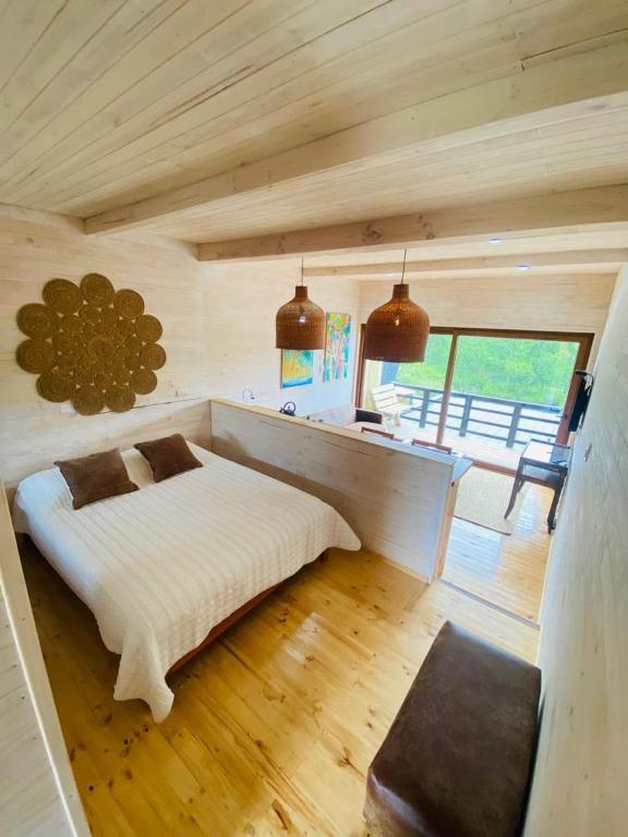 皮奇勒姆Forest house Cabaña para 2的木制客房内的一间白色床卧室