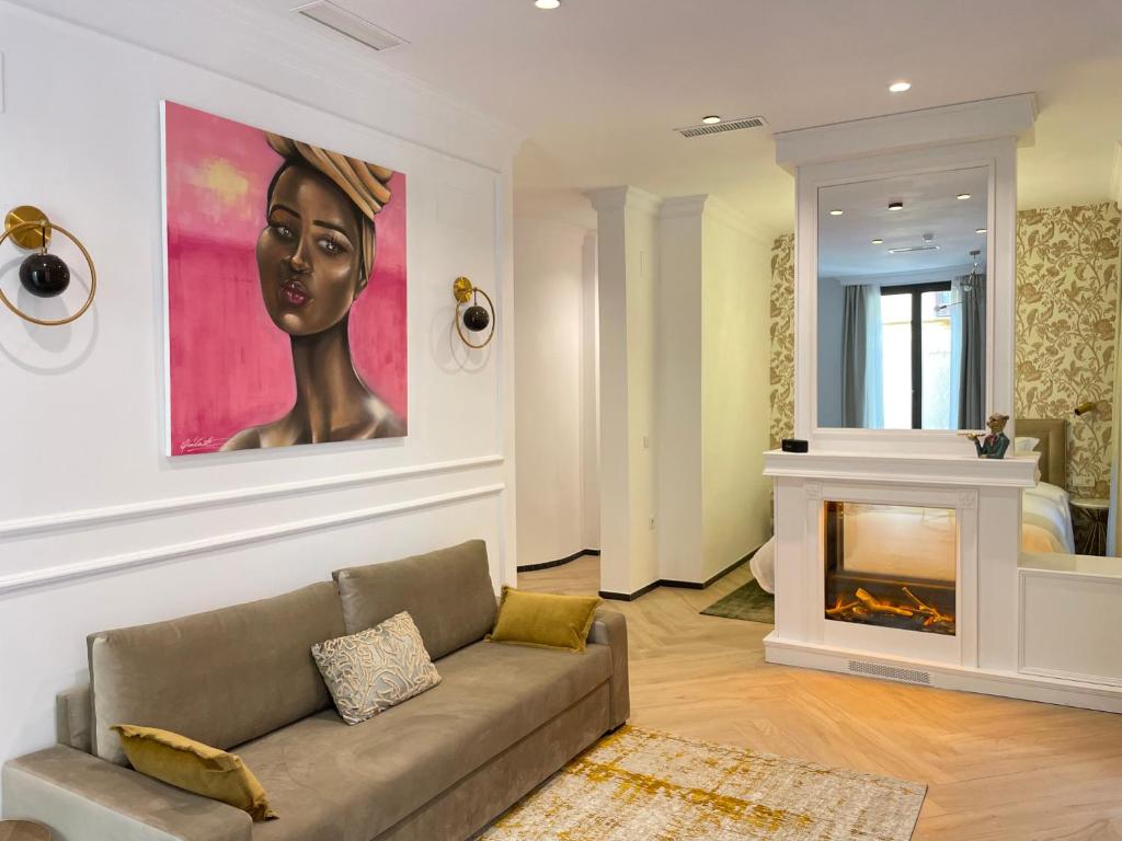 格拉纳达Bubaqia House - Suites Boutique的客厅配有沙发和墙上的绘画