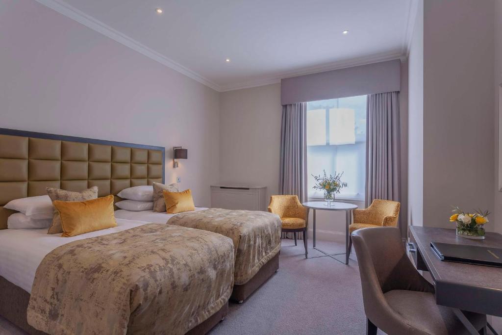 威布里治欧特兰德公园酒店的酒店客房设有两张床和一张桌子。