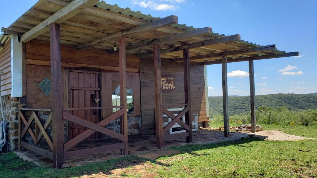 塔夸伦博Cabaña en el campo的小木屋设有门和遮阳篷