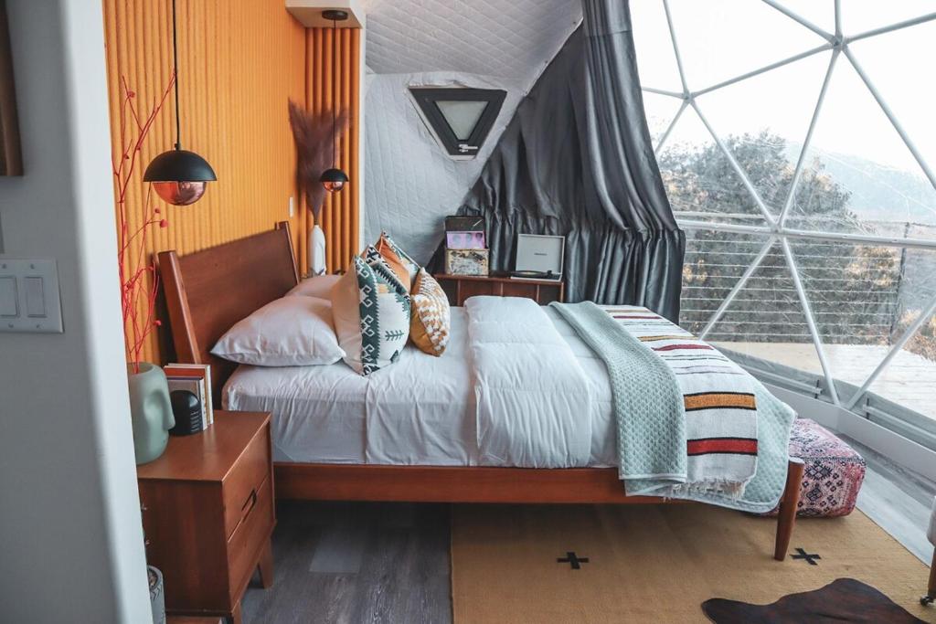 NogalZia Geo Dome At El Mistico Ranch, Glamping的一间卧室设有一张床和一个大窗户