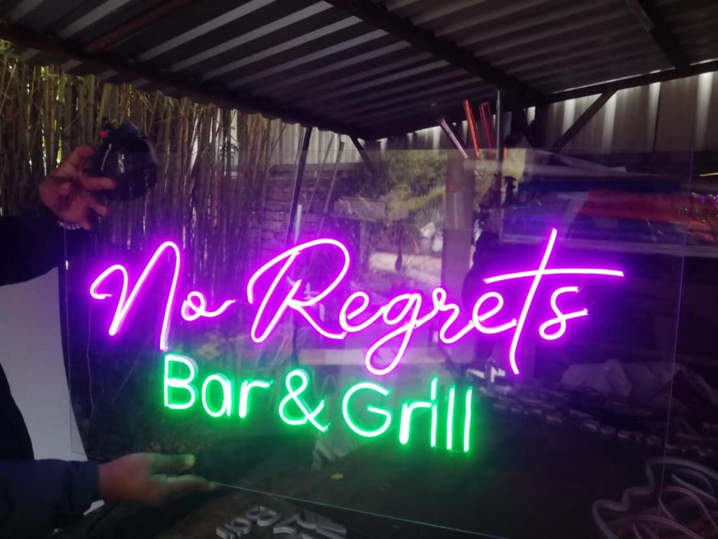 Coxen HoleNo Regrets的 ⁇ 虹灯标志,没有表示遗憾的酒吧和烧烤