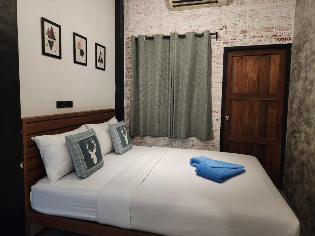 沙美岛Baan Minnie 2 bedroom home 400m from Saikaew beach的卧室配有带蓝色枕头的大型白色床