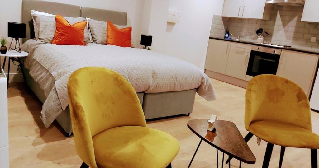北安普敦Market Haven Kingsize Studios Town Centre with Netflix, Business & Leisure travellers, multiple units available的一间卧室配有两张黄色椅子和一张床