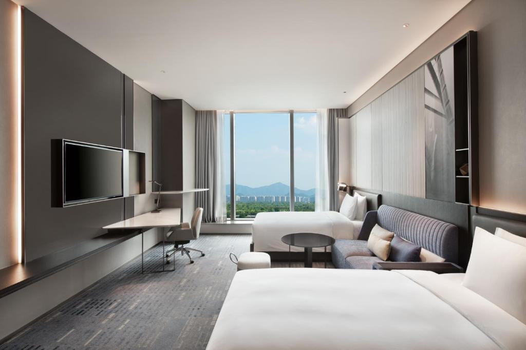 杭州杭州奥克斯中心皇冠假日酒店的配有一张床和一张书桌的酒店客房
