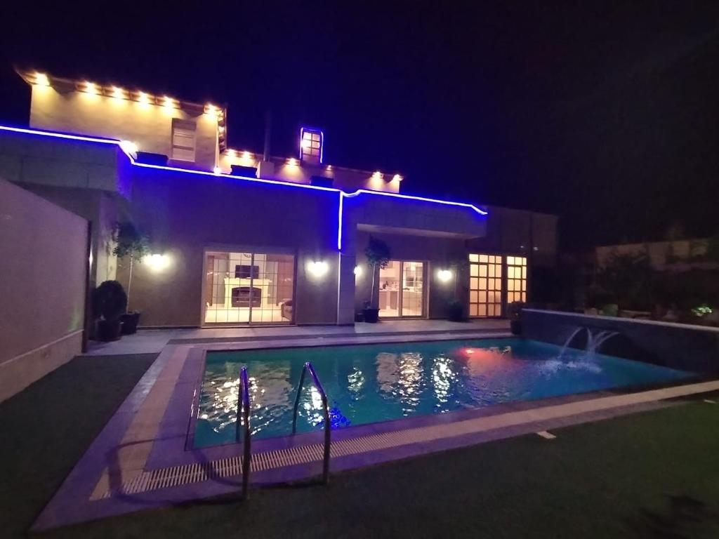 马达巴The Oaks的夜间在房子前面的游泳池