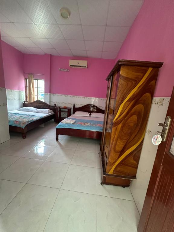 美奈San Vuon Guesthouse的一间设有两张床和紫色墙壁的客房