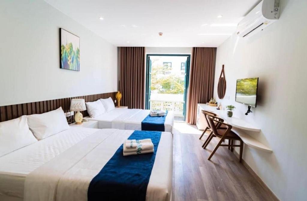 富国Larosa Hotel的酒店客房配有两张床和一张书桌