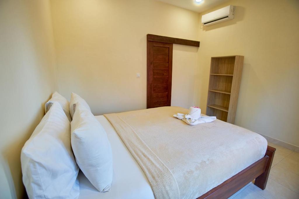 蓝梦岛Risna Homestay的一间卧室配有带白色床单和枕头的床。