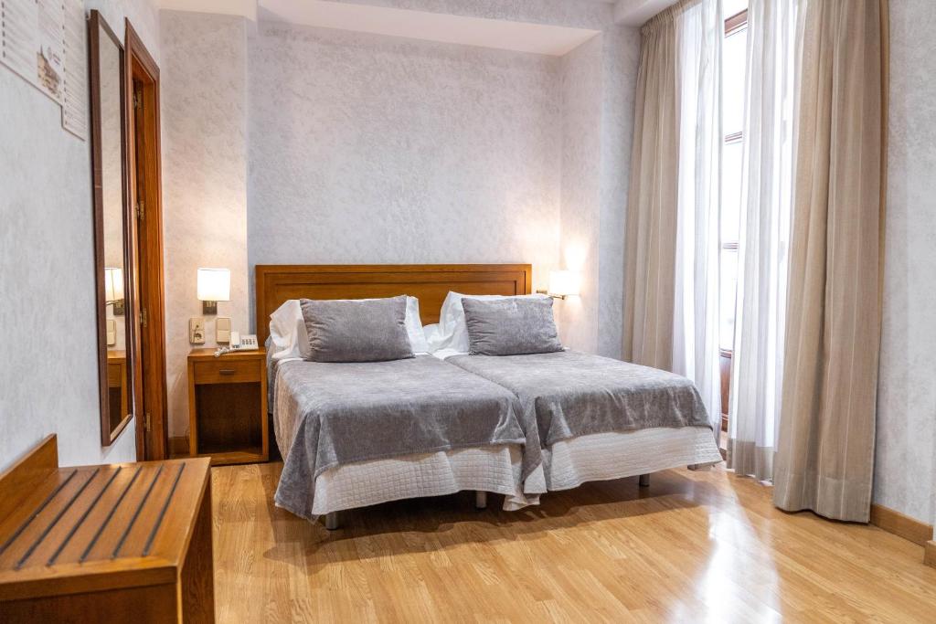 格拉纳达格拉纳达中心酒店的一间卧室配有一张床、一张桌子和一个窗户。