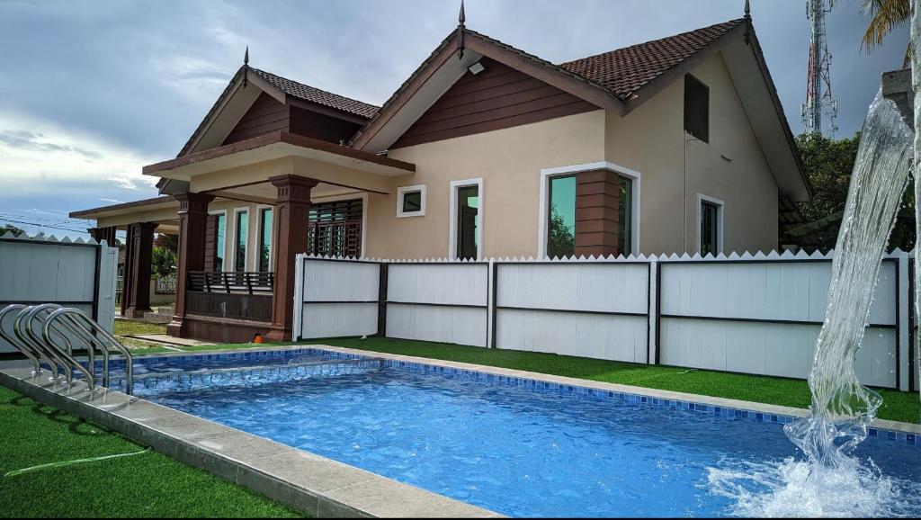 Kampung RajaTeratak Ammara Homestay Besut with private pool的房屋前有游泳池的房子