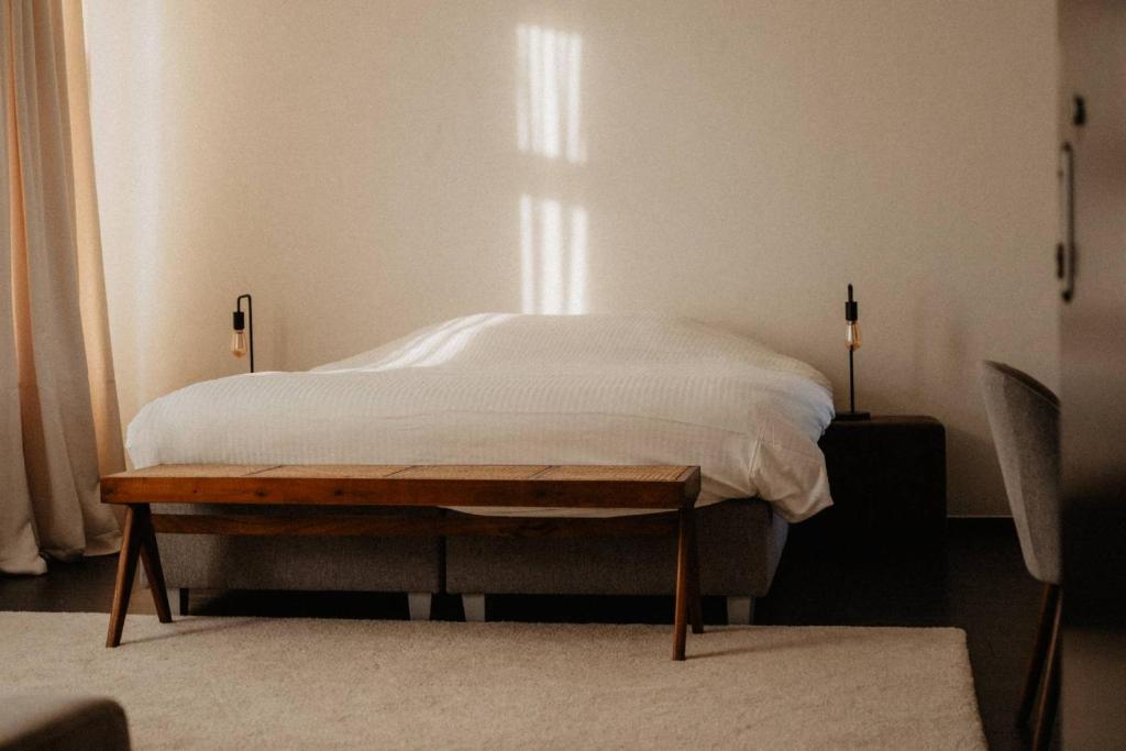 博尔赫隆Huize Schaberg的一间卧室配有一张带白色床单的床和一扇窗户。