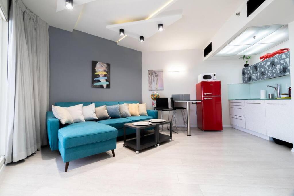 巴特亚姆Sweet Love - דירה מהממת על הים עם נוף的客厅配有蓝色沙发和红色冰箱