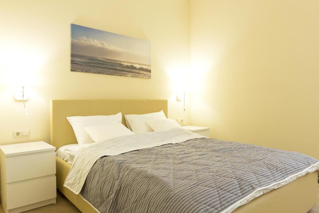 阿克套MIRAMAR Apart Hotel & SPA的一间卧室配有一张带2个床头柜和2盏灯的床。