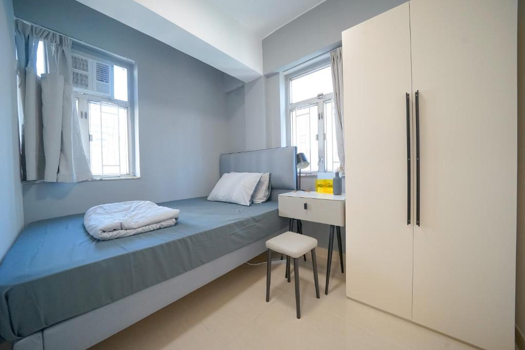 香港Student Accommodation - 290 Hennessy Road的一间卧室配有一张带桌子和椅子的床