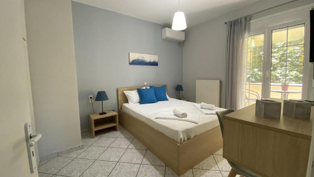 雷夫卡达镇Lefkada Blue - Apartments的一间卧室配有一张带蓝色枕头的床和一扇窗户。