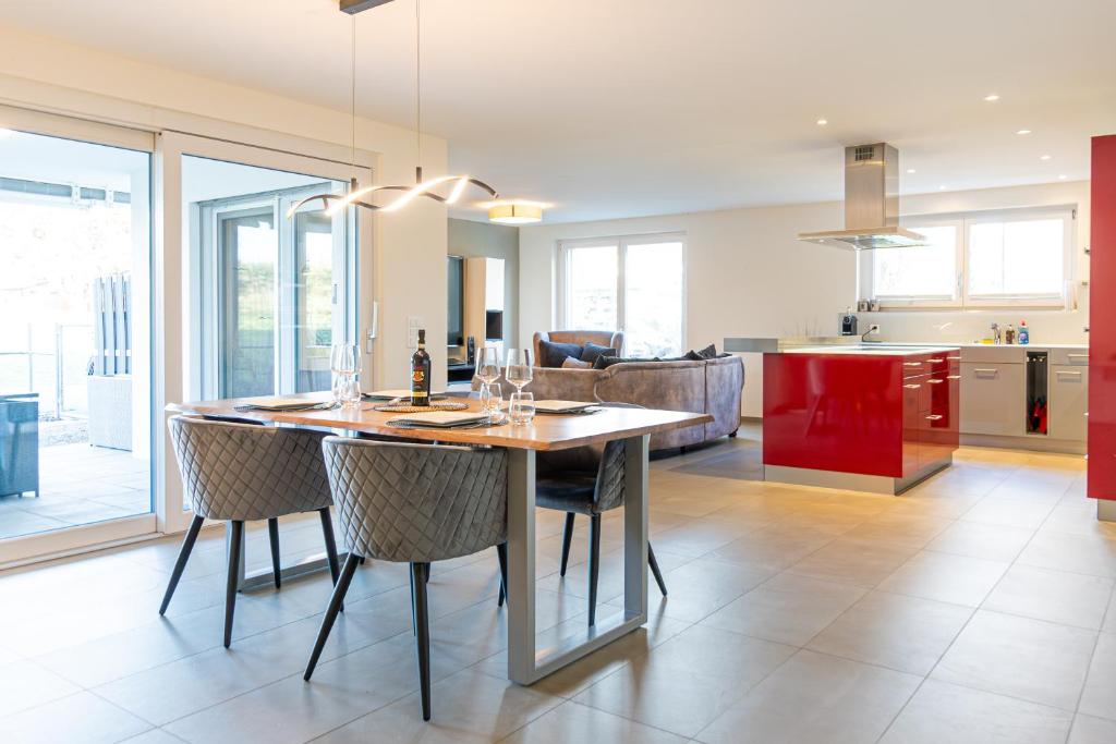 施泰因Luxus 3,5 Zi-Whg 128m2, 8 Min zum See & Altstadt的厨房以及带木桌和椅子的客厅。