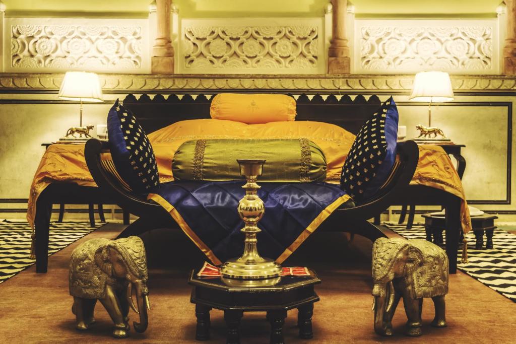 斋浦尔The Umaid Vilas Royal Heritage Haveli的一间卧室,配有一张带奖杯的床
