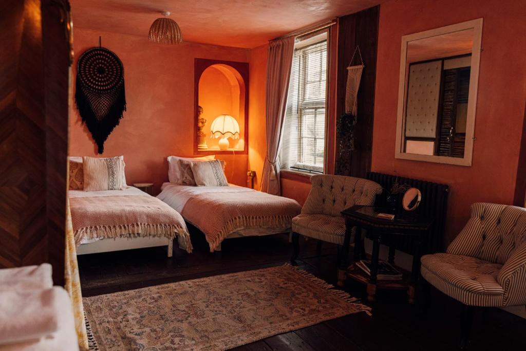 KentThe George & Heart House的一间卧室配有两张床、一把椅子和镜子