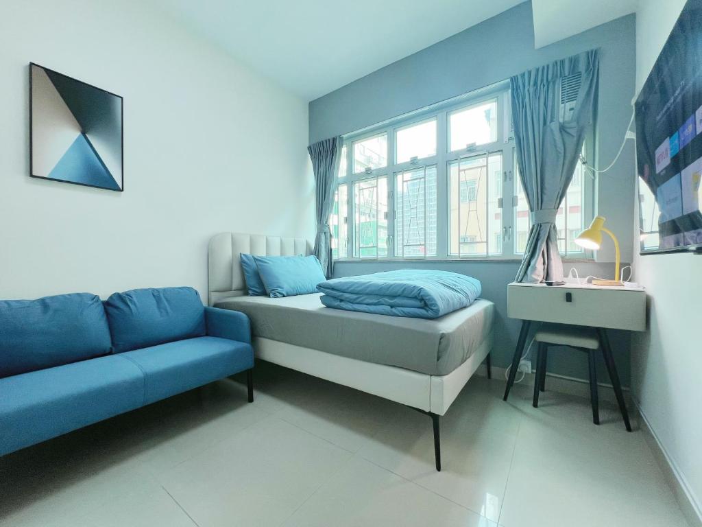 香港Student Accommodation - 26 Man Yuen Street的一间卧室配有一张床、一张沙发和一个窗口