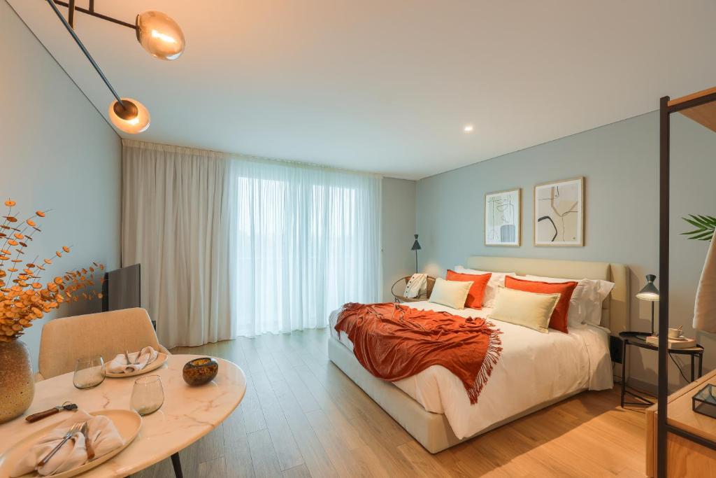 波尔图Icon Apartments by NÔMA的一间卧室配有一张大床和一张桌子