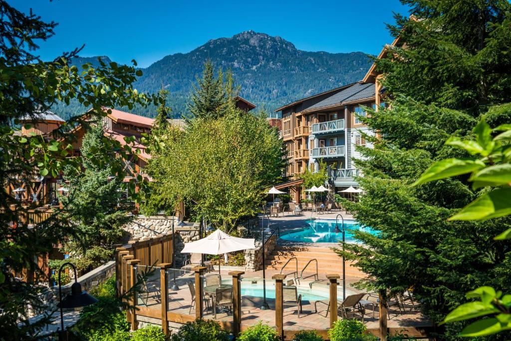 惠斯勒传奇酒店的背景为一座带游泳池和山脉的酒店