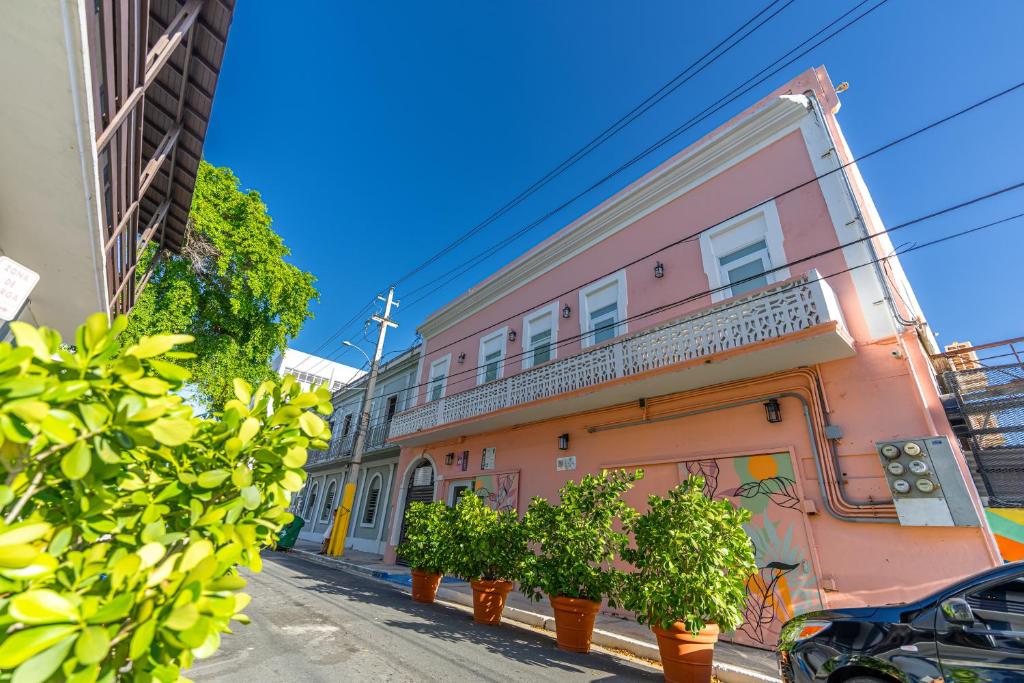圣胡安Juliette Hostel Digital Nomad Women Only的街上有盆栽的粉红色建筑