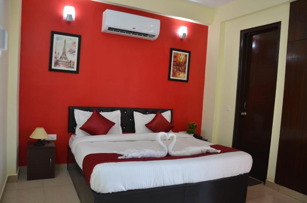 诺伊达Rumaisa Red的卧室设有一张红色的墙壁和一张床