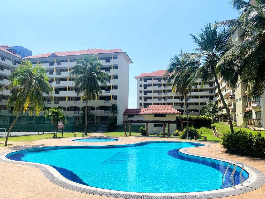 波德申Izdisa Muslim Homestay Teluk Kemang Groundfloor unit with Pool view的棕榈树建筑前的游泳池