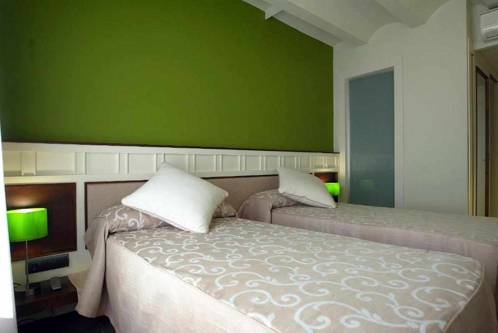 莫雷拉方达莫雷诺酒店的一间卧室设有两张床和绿色的墙壁