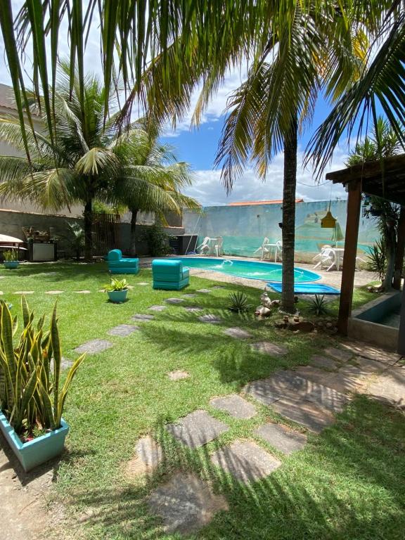 萨夸雷马Casa de Praia Suítes的后院设有棕榈树游泳池