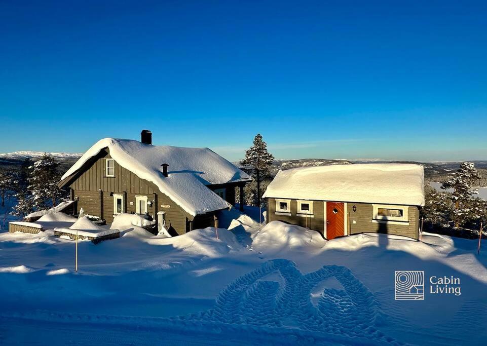 兰帕兰德Cozy cabin with incredible views and sauna的前面的雪覆盖的房子