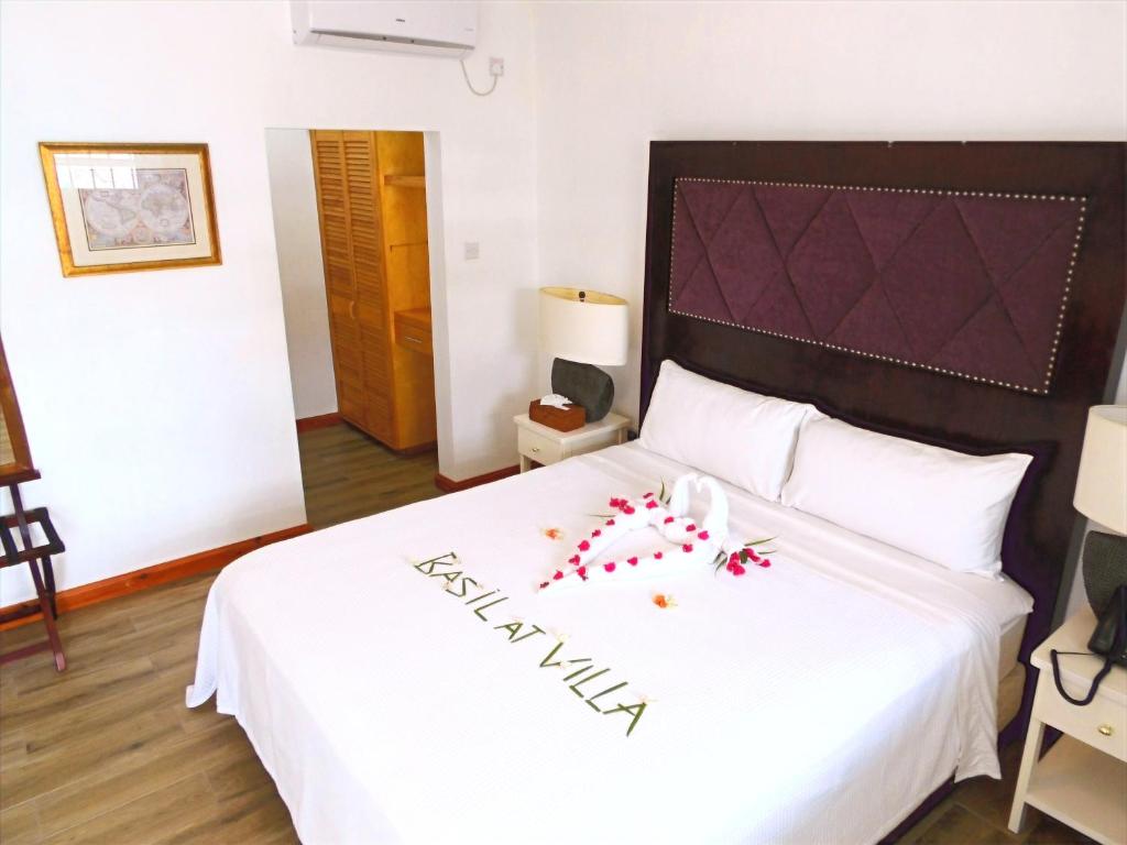 Arnos ValeBasil At Villa的一间卧室配有白色床单和红色鲜花。