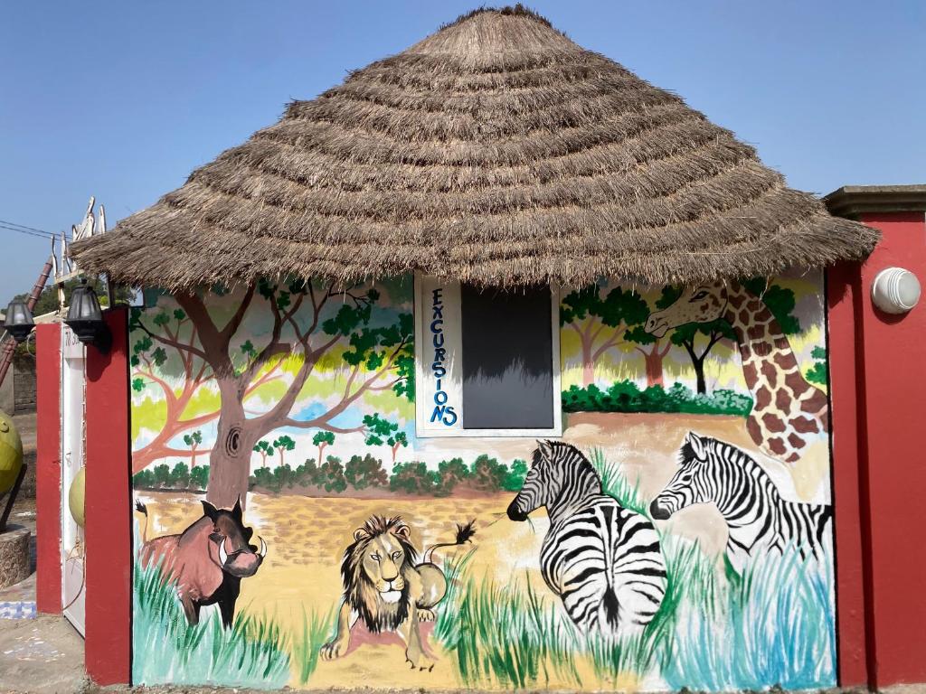 ToubakoutaLa kora的一座建筑,上面有斑马和长颈鹿的画作