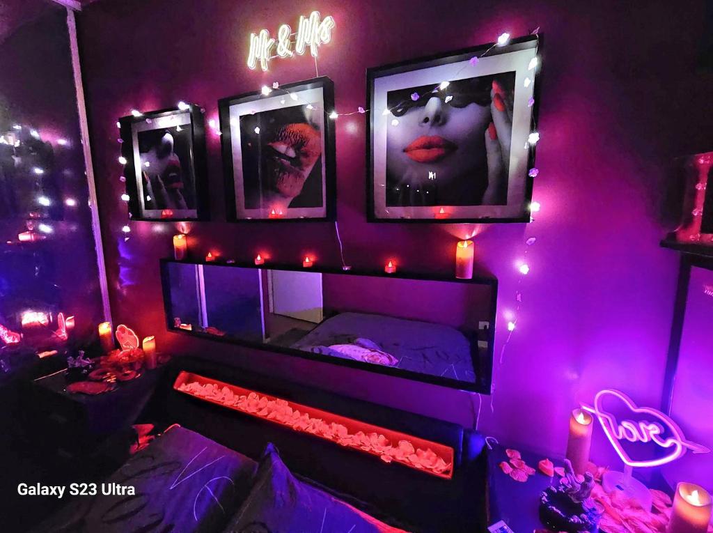 欧奈索斯博伊斯Love Room Amour Glamour Lib proche gare rer 5 minute à pied的紫色灯和一张带镜子的床的房间