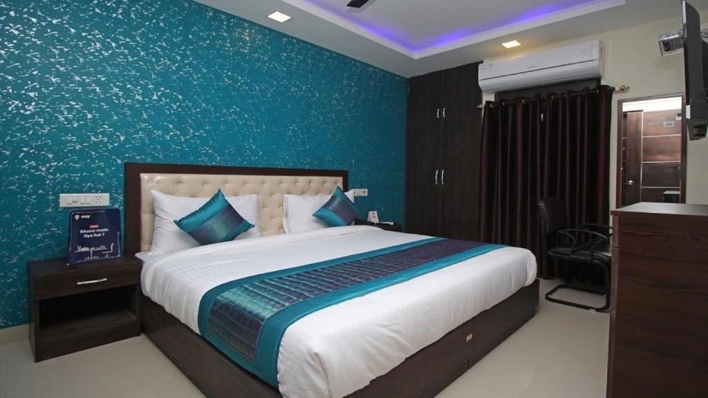 新德里Airport T Palace的一间卧室设有一张蓝色墙壁的大床