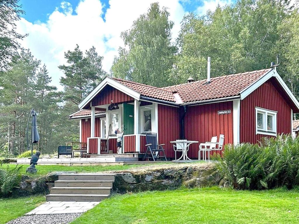 EckerudHoliday home PRÄSSEBO II的前面有一张桌子和椅子的红色房子