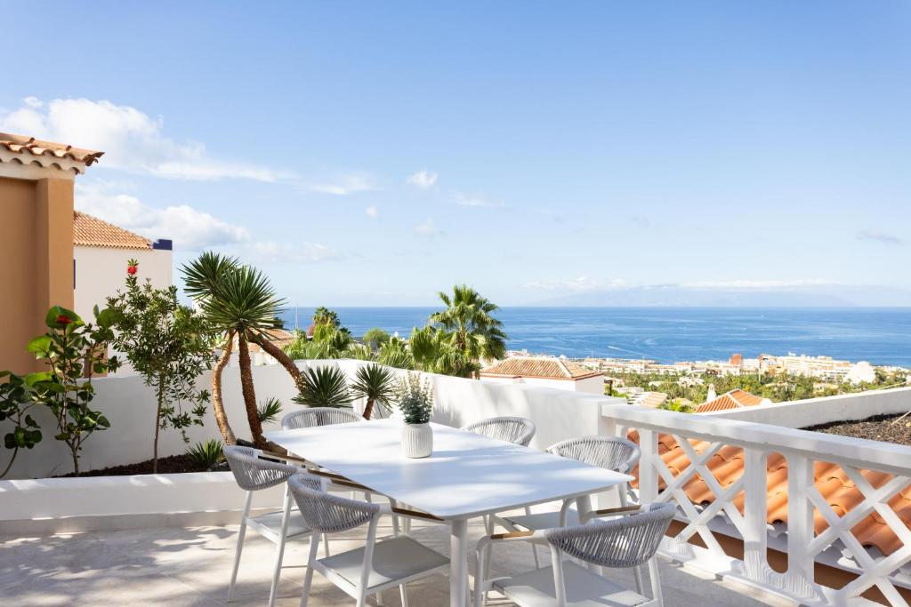 阿德耶Elysium Ocean Villa的阳台上配有白色的桌椅,享有海景