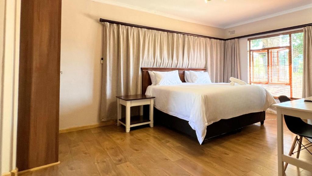 开普敦Kabana Family Home and Guest House的一间卧室设有一张大床和一个窗户。