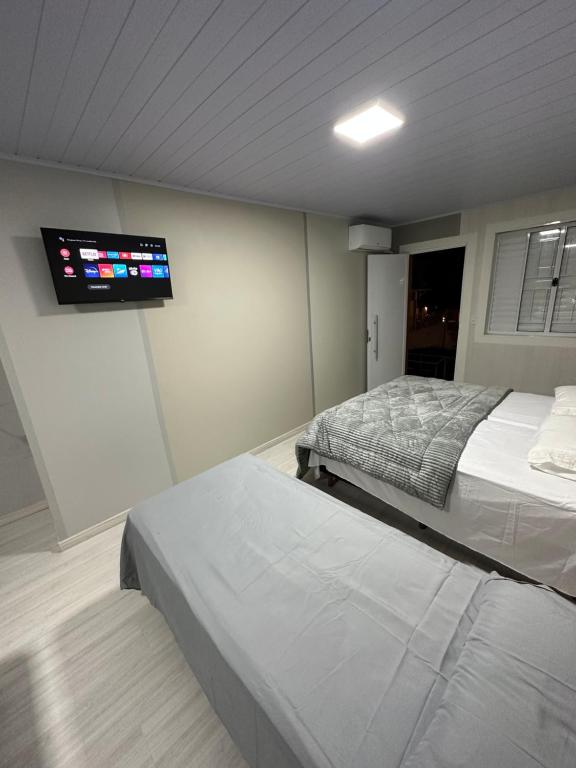 沙佩科Loft Lux 3的一间卧室设有两张床,墙上配有电视。