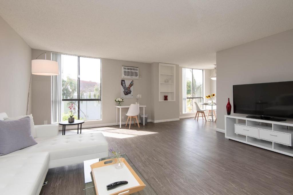 洛杉矶Prime Location 1-Bedroom with Pool的客厅配有白色沙发和平面电视。