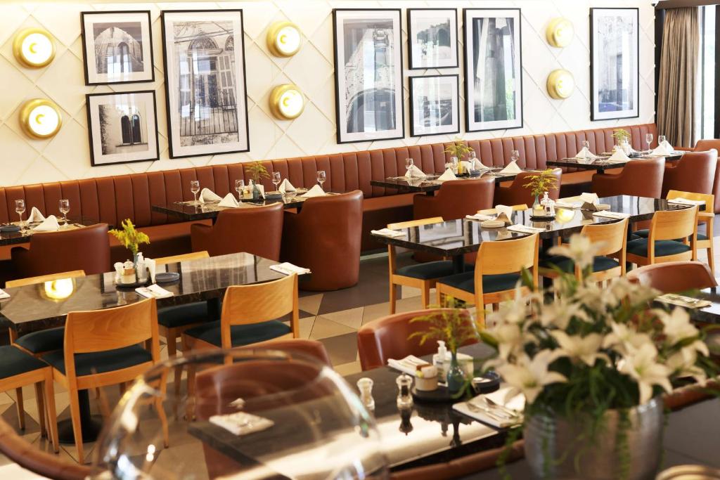 贝鲁特贝鲁特凡尔登丽笙酒店的餐厅用餐室配有桌椅