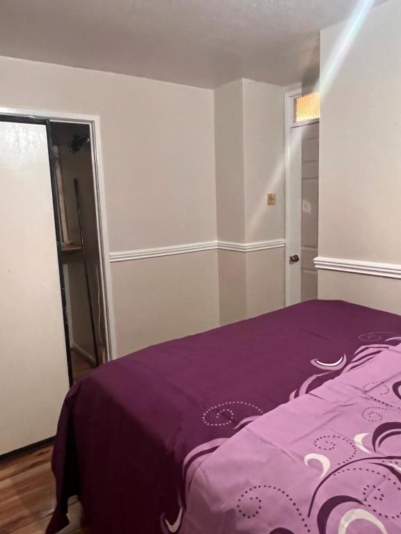 ThurcastonA&G的一间卧室,在房间内配有一张紫色的床