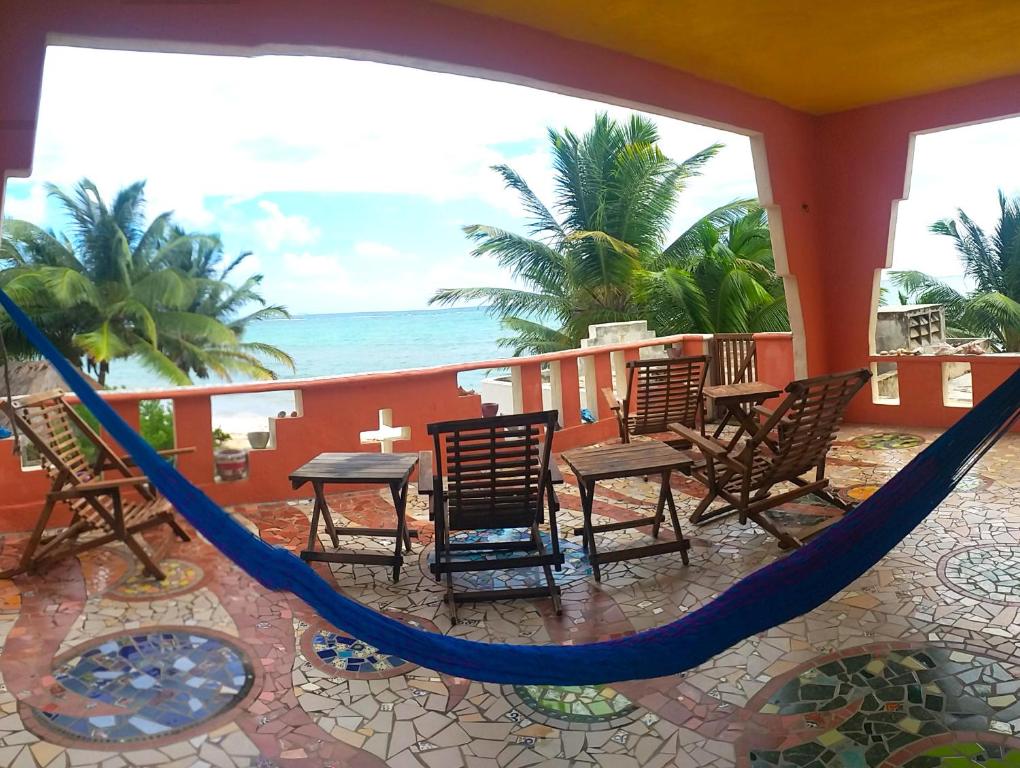 El PlacerMayan Beach Garden的一个带椅子和吊床的门廊和大海