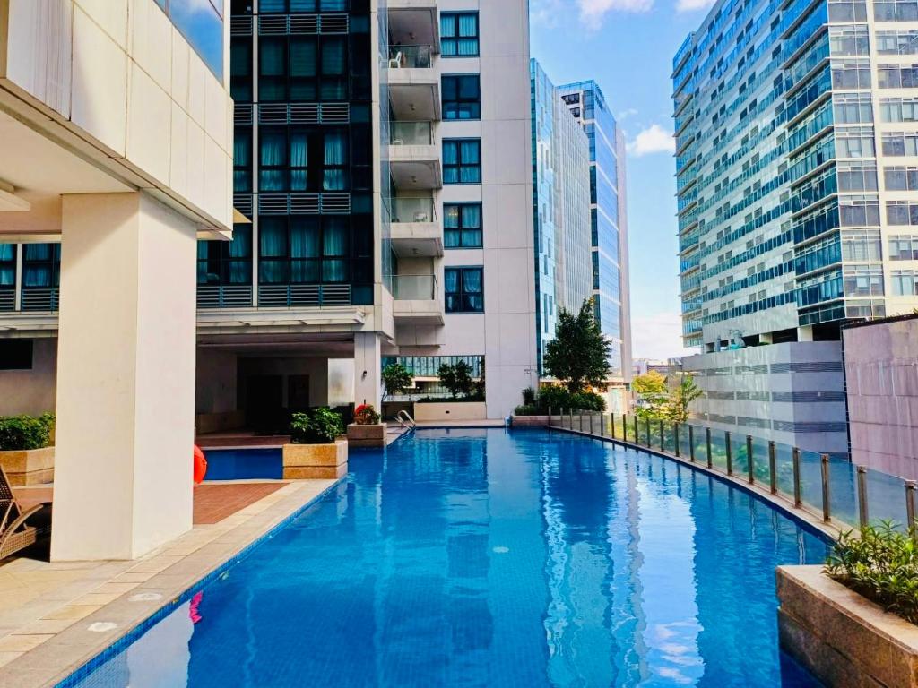 马尼拉Deluxe Queen 1BR Luxury Suite 11 - Pool, City View的一座高楼内的游泳池