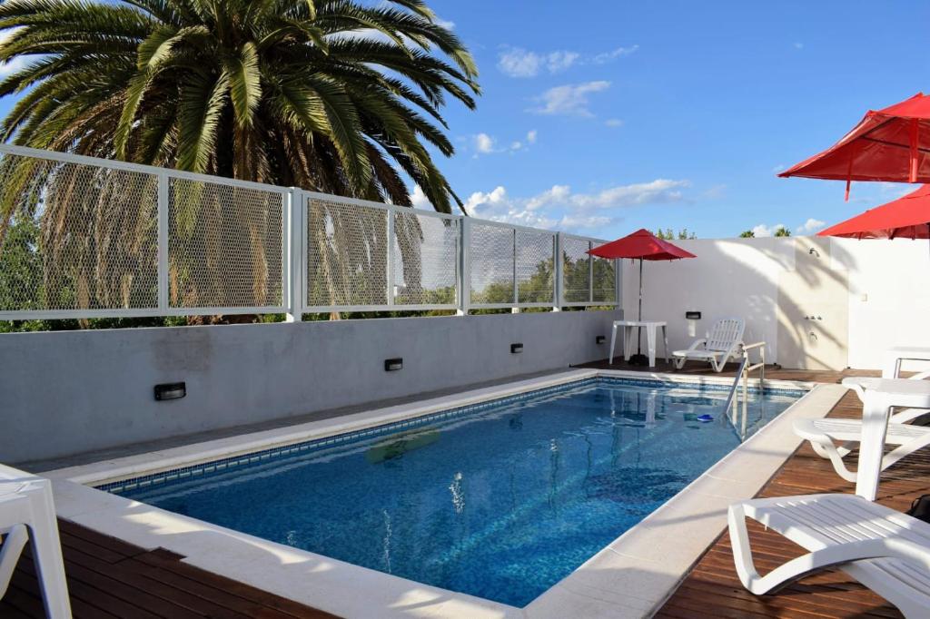 科隆Catalina Hotel的一座大楼内的游泳池,配有椅子和遮阳伞