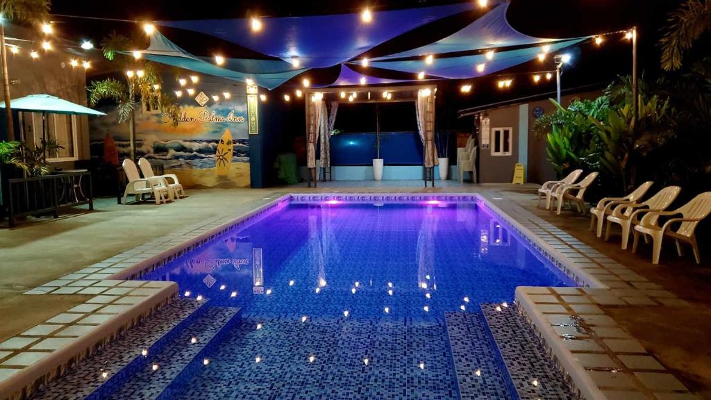 圣胡安Hidden Palms Inn/Resort La Union的夜间游泳池,带灯光和帐篷